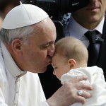 Pope Francis kisses a baby.