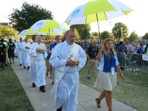 Deacons, accompanied by student volunteers, process to Mass in order to distribute communion. 