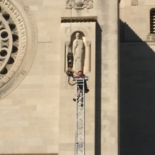 A member of the construction crew works on the top of a support for the roof over the papal altar.