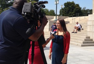 CUA junior Angela Fragale is interviewed by a TV reporter about being chosen as one of the escorts for the deacons who will distribute communion at the papal Mass.