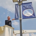 Catholic University President John Garvey is seen with new Welcome Pope Francis banners, now displayed on the University Mall.