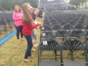 Student volunteers label chairs for Wednesday's papal Mass. 