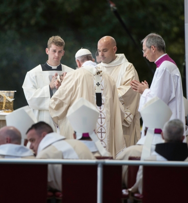 Pope Francis assisted by a deacon and servers