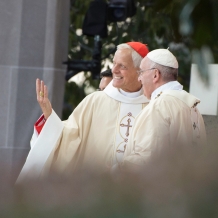 Cardinal Wuerl gestures to the crowd as he speaks to Pope Francis