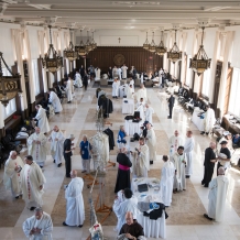 Priests vesting for Mass in Heritage Hall