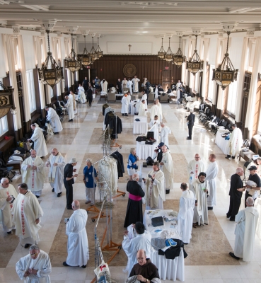 Priests vesting for Mass in Heritage Hall