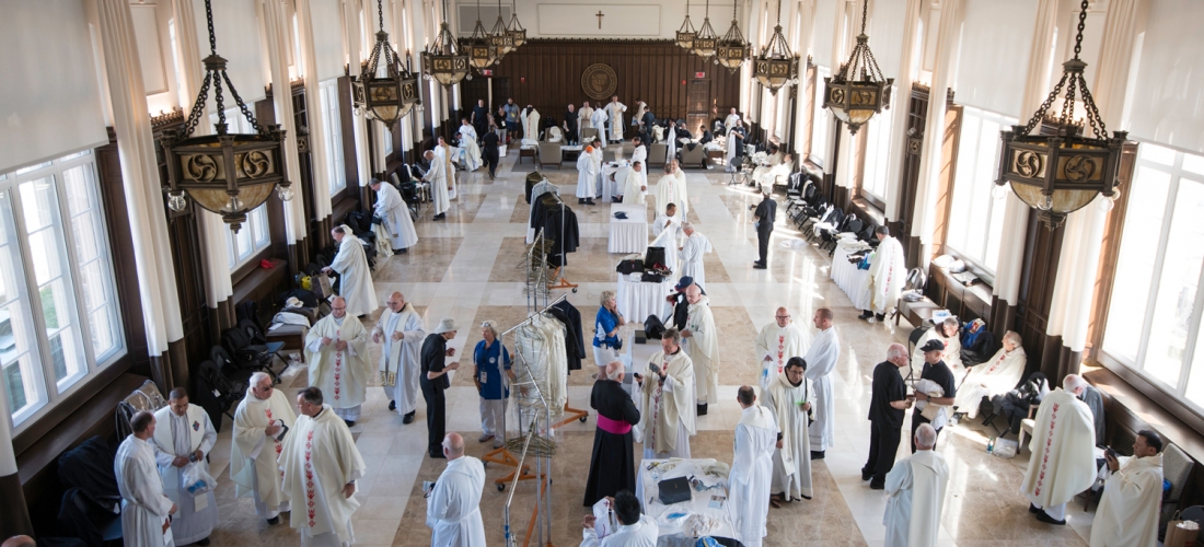 Priests vesting for Mass in Heritage Hall