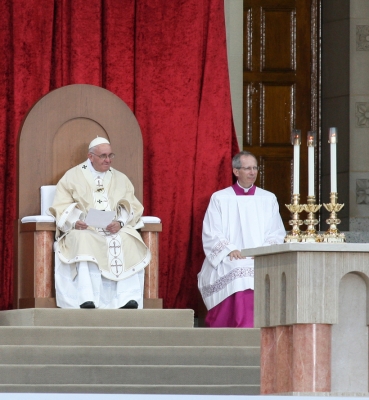 Pope Francis seated in the chair designed by CUA students.