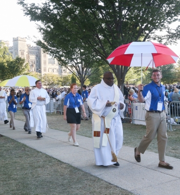 Deacons distributing Communion were escorted by volunteers carrying umbrellas.