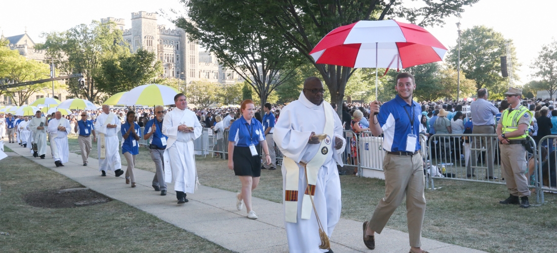 Deacons distributing Communion were escorted by volunteers carrying umbrellas.