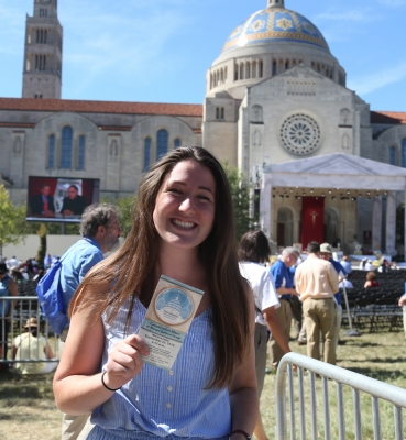 A student with her ticket and the Basilica in the background.