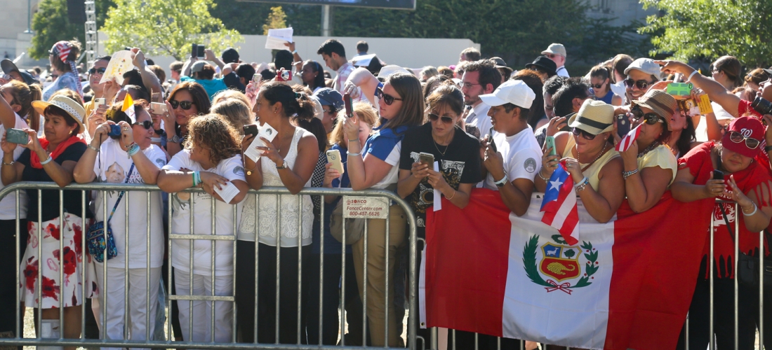 People in the crowd with smartphones poised to photograph the Pope