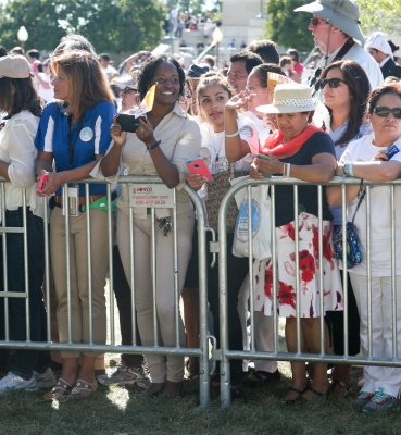 Waiting at the fence line for the popemobile to pass by.