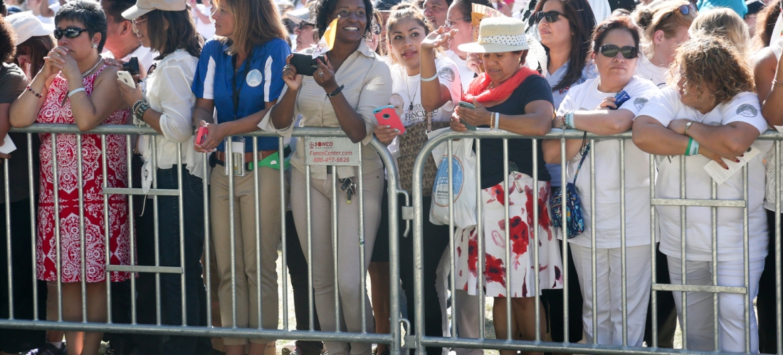 Waiting at the fence line for the popemobile to pass by.