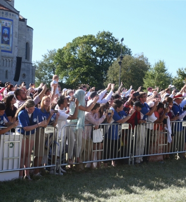 The crowd waves as Pope Francis passes by on the University Mall.