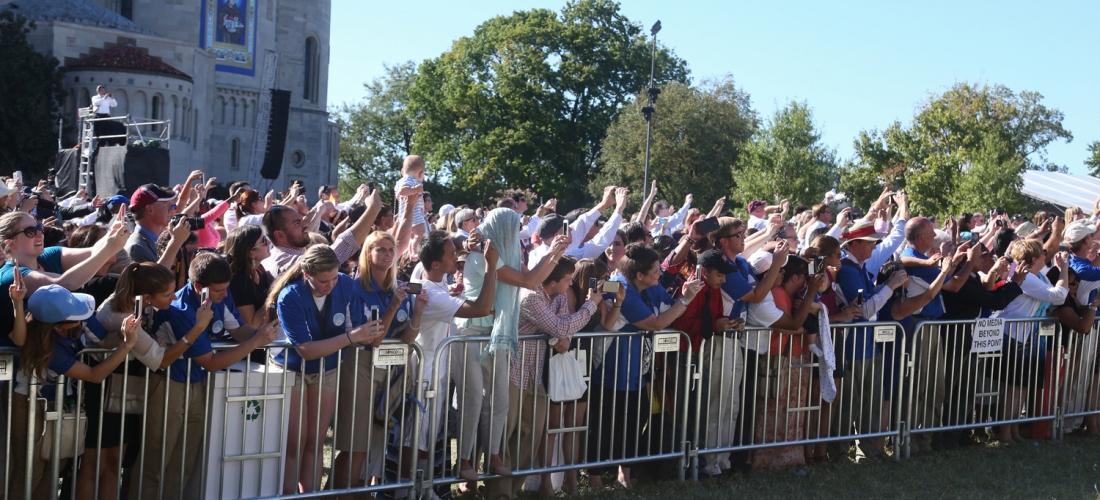 The crowd waves as Pope Francis passes by on the University Mall.