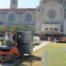 A forklift driver delivers building supplies to a construction site on campus.