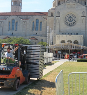 A forklift driver delivers building supplies to a construction site on campus.