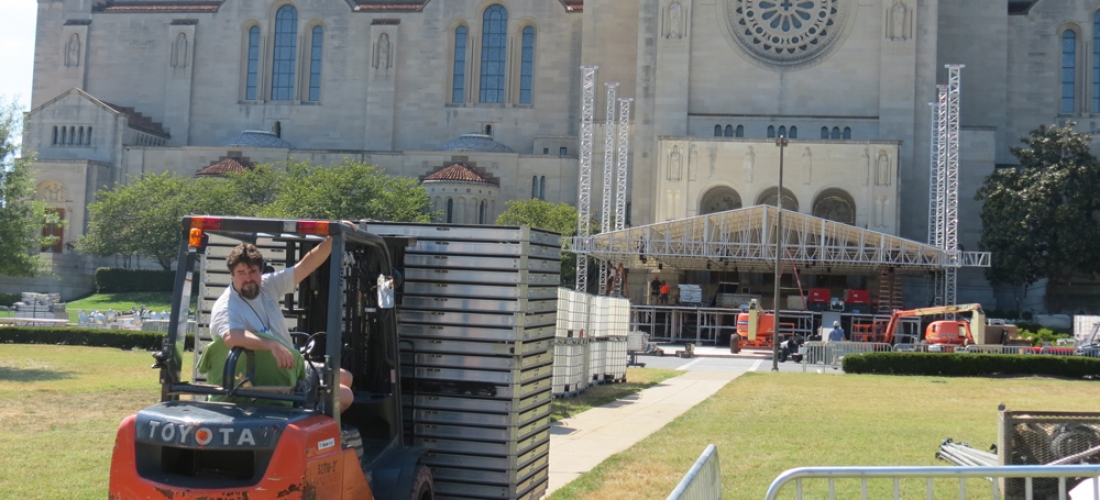 A forklift driver delivers building supplies to a construction site on campus.