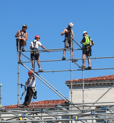 Workers building the 10-level media riser construct the top tier.