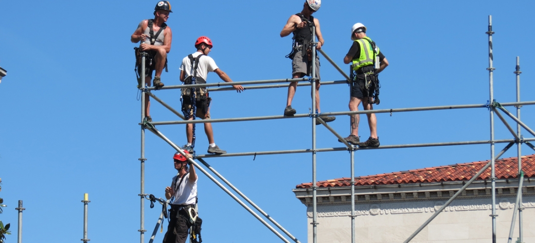 Workers building the 10-level media riser construct the top tier.