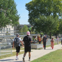 Students walk through fencing on the University Mall past the media riser under construction.