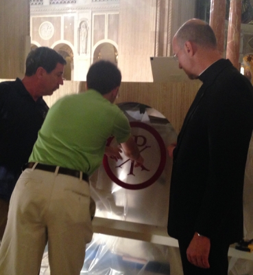 CUA student Matthew Hoffman, carpenter Deacon David Cahoon, and Basilica Rector Monsignor Walter Rossi discuss placement of a mosaic on the altar.