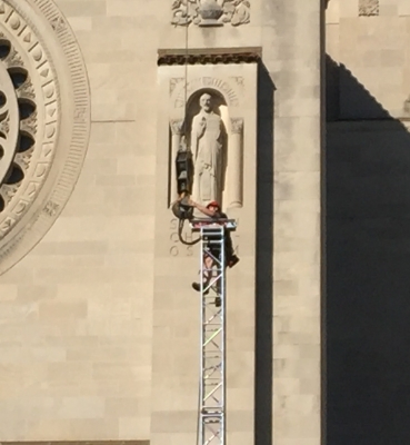 A member of the construction crew works on the top of a support for the roof over the papal altar.