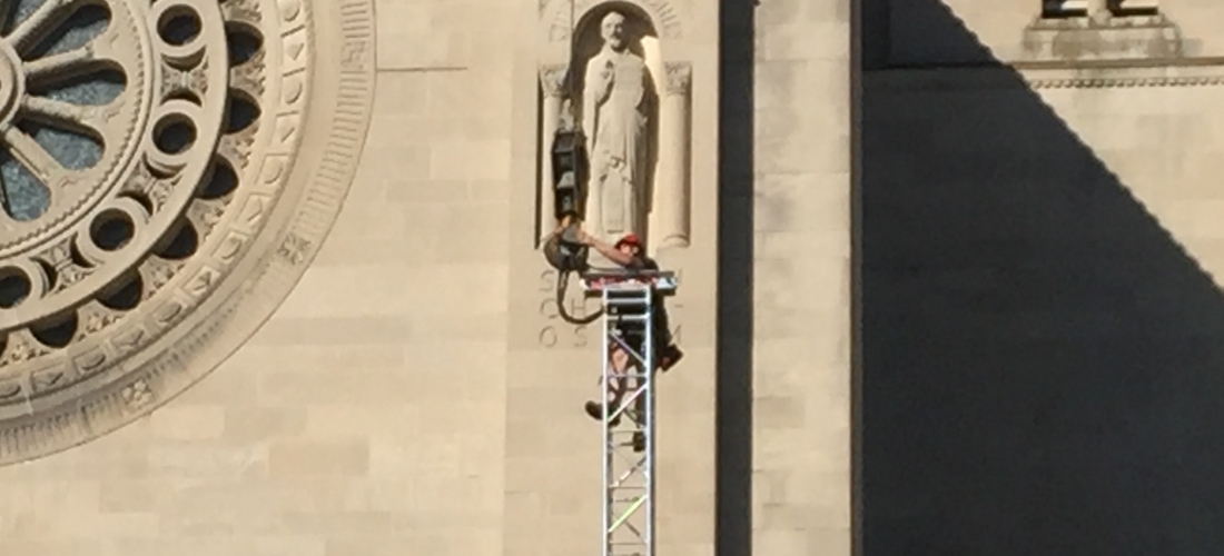A member of the construction crew works on the top of a support for the roof over the papal altar.